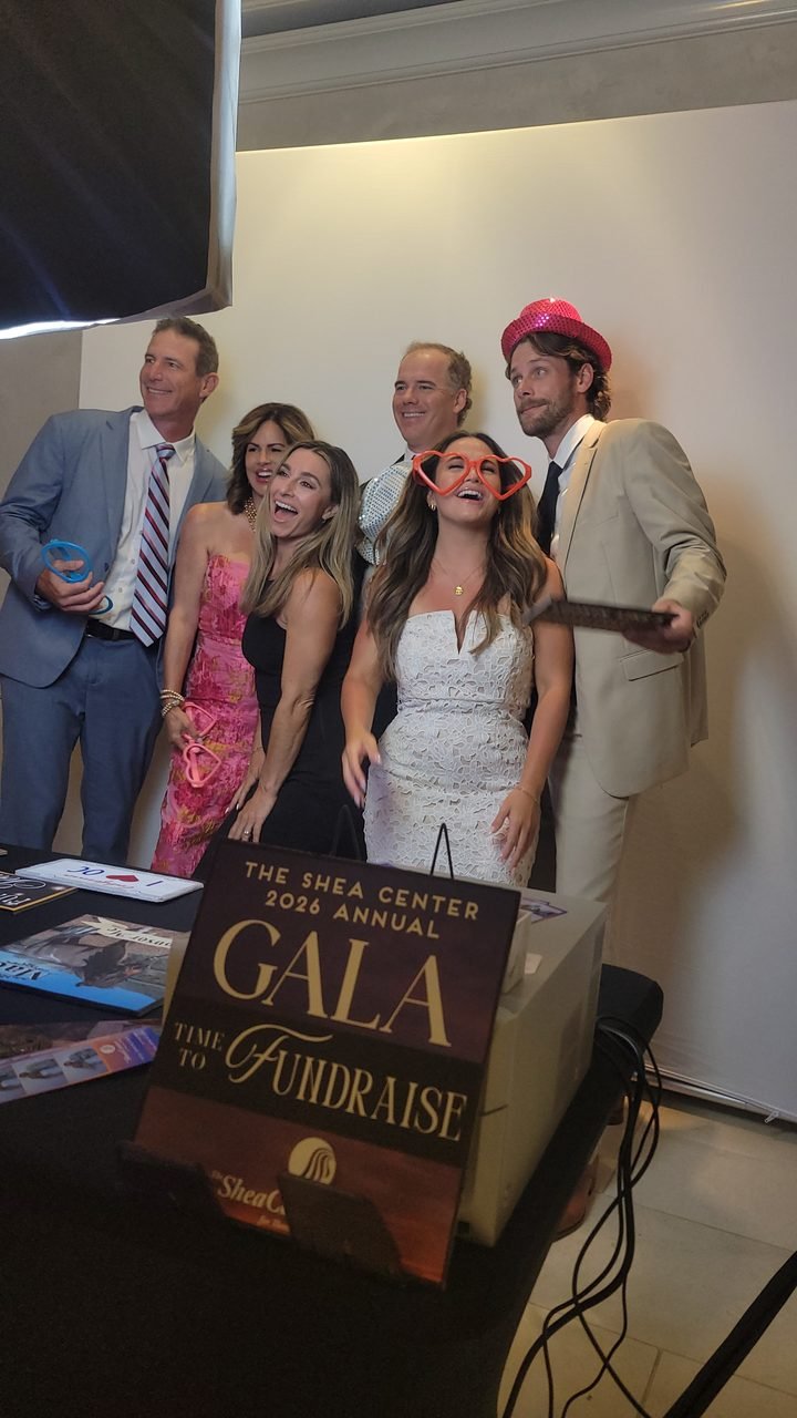 A group of guests crowding into the SoCalFun365 photo booth at a charity gala in Orange County